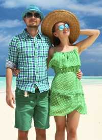 A man and woman wearing hats and sunglasses on a beach.