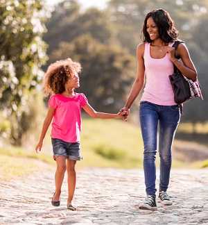 mother and daughter walking outside holding hands