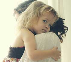 Una niña pequeña en los brazos de su madre