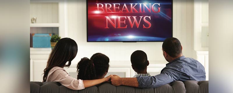 Family watching breaking news alert on television