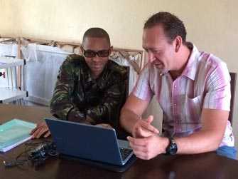 CDC Disease Detective Greg (left) works on Ebola contact tracing with officers from Sierra Leone’s Armed Forces.