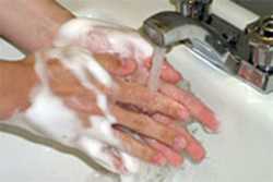Washing hands with warm water and soap.