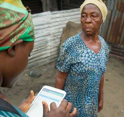 Contact tracer Dorissa Bestman uses a tablet to follow up on her daily contacts in the New Cru Town section of Monrovia, Liberia. A trial program conducted by CDC partner eHealth Africa in Liberia is using technology to load and store data where pencil and paper is the standard. 