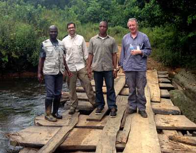 José Hagan (second from left) and his World Health Organization and County Health Department colleagues stand on a bridge they had to reconstruct to communicate with nearby villages.