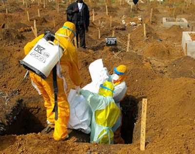 Burial team buries an Ebola victim in Sierra Leone.