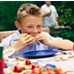 Photo: Young boy eating at a picnic