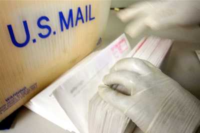 Gloved hands sorting through mail during 2001 anthrax scare