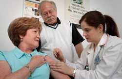 A doctor giving a flu shot to a female patient