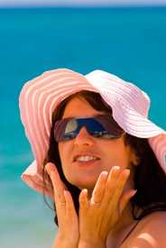 Foto de una mujer al aire libre con un sombrero y gafas.