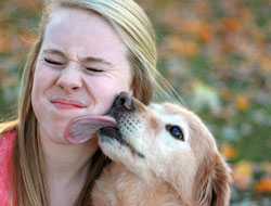 image of dog licking a young woman's face