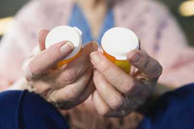 Woman holding two bottles of pills