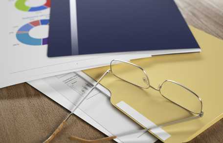 Photo of papers, folders, and a pair of glasses