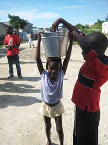 	A girl carrying a pail of water.