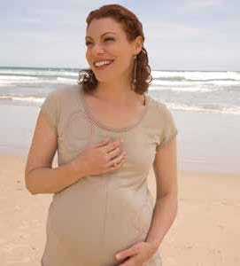 pregnant woman standing on the beach