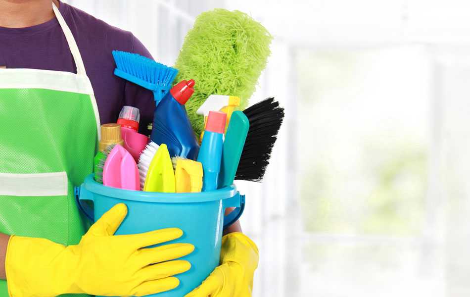 person with safety cleaning gloves holding bucket filled with cleaning supplies