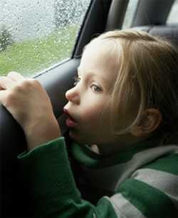 Photo of a young girl looking out a car window