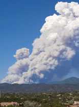 Photo of smoke rising from a mountian landscape.