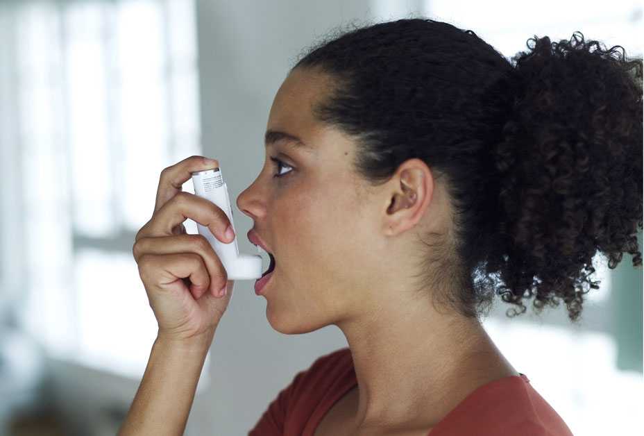 Young woman using an inhaler