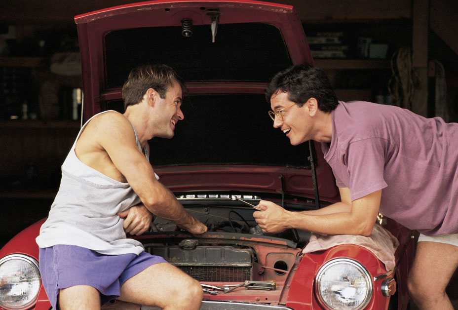 Two guys working on an old car