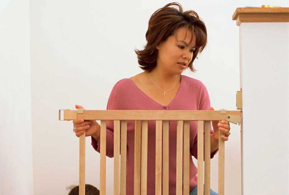 Mother securing baby gate