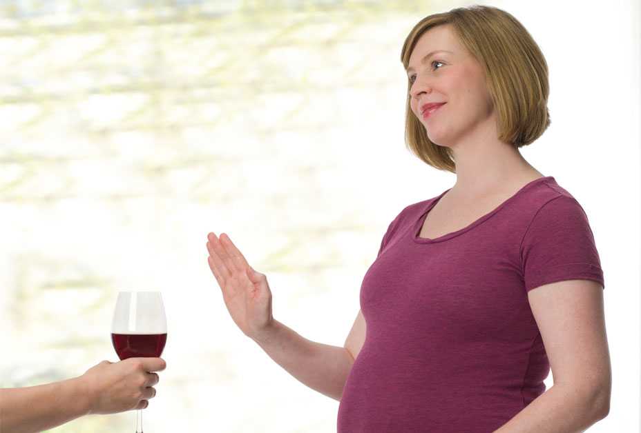 Pregnant woman saying no to glass of wine