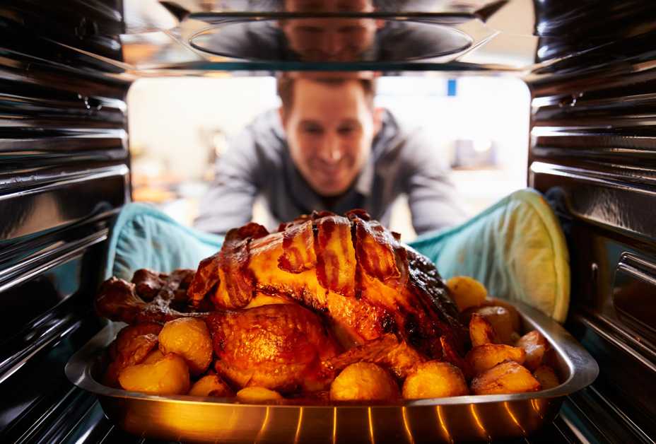 Man checking turkey in oven