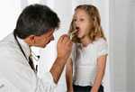Doctor examining girl's throat