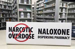 Photo: Sign on pharmacy counter: No narcotic overdose. Naloxone dispensing pharmacy.