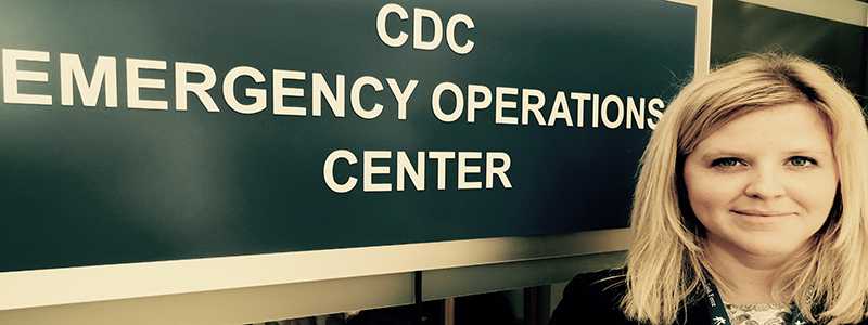 Molly Fitch standing in front of CDC Emergency Operations Center Sign
