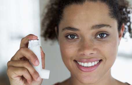Woman holding inhaler and smiling