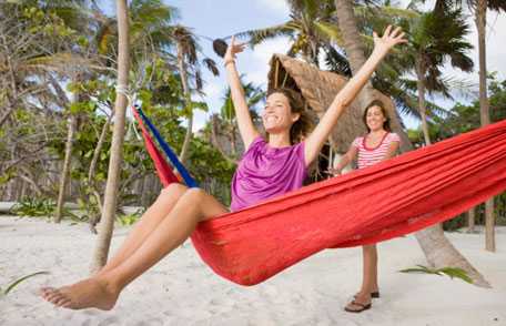 Woman swinging in hammock on beach