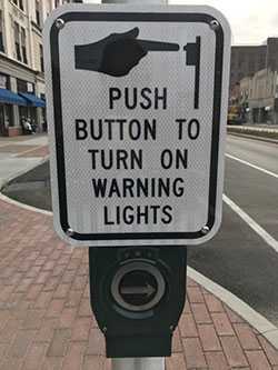 Accessible street sign says Push Button to Turn on Warning Lights