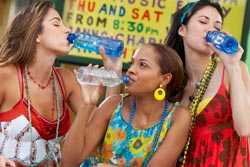 Three young women drinking water from bottles