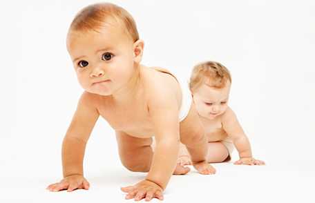 Two babies crawling on floor