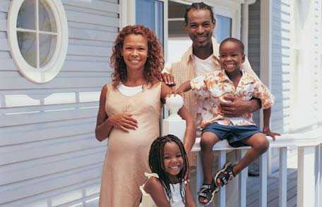 Family of four on front porch of home
