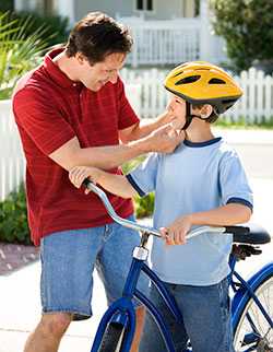 Father fastening son's bike helmet