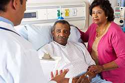 Doctor speaking with hospital patient and his wife