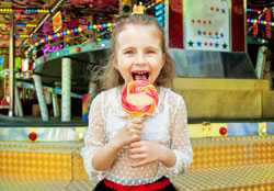 Girl licking lollipop at carnival