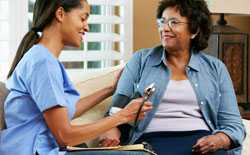 Healthcare worker taking woman's blood pressure