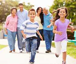 Children running down path with parents and grandparents walking behind them
