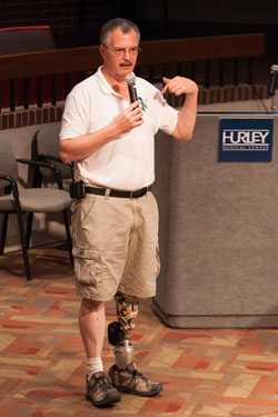 Dave at a speaking engagement using his prosthetic leg