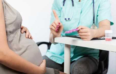 Pregnant woman and doctor consulting about medications