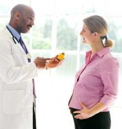 A healthcare professional consulting a pregnant woman about medicine usage