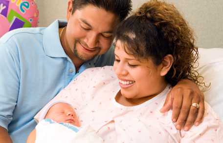Mother and father smiling at newborn