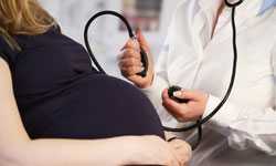 Pregnant woman having blood pressure taken