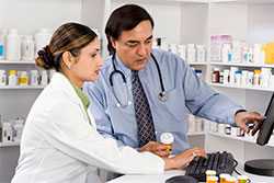 Two pharmacists looking at computer monitor