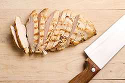 Cut chicken breast and knife on cutting board