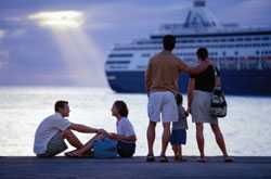 Family standing on dock with cruise ship in distance