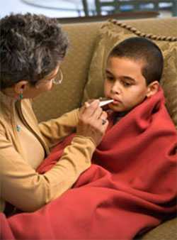 Photo: Mother checking son's temperature