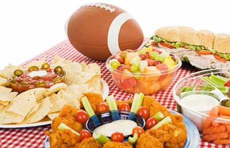 Football on table of snacks and sandwiches